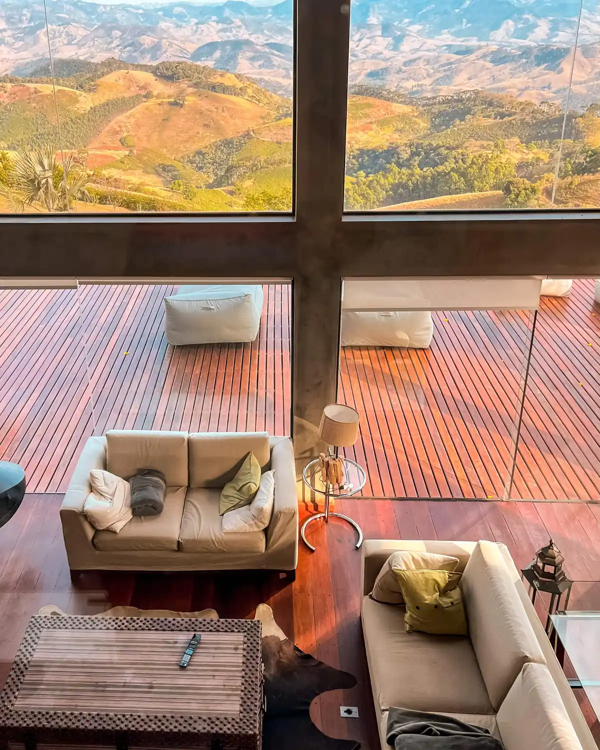 Mezanino de madeira sobre a sala, olhando para as paredes de vidro e o vale
