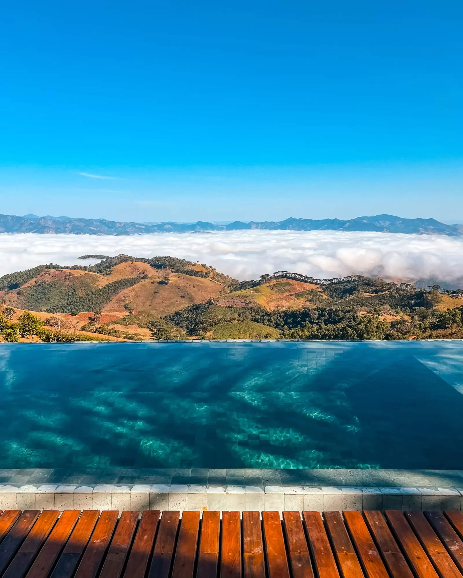 A piscina de borda infinita com o mar de nuvens preenchendo o vale ao fundo